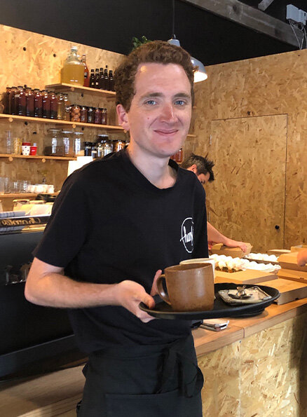 James, one of our participants, carrying an order to a table.